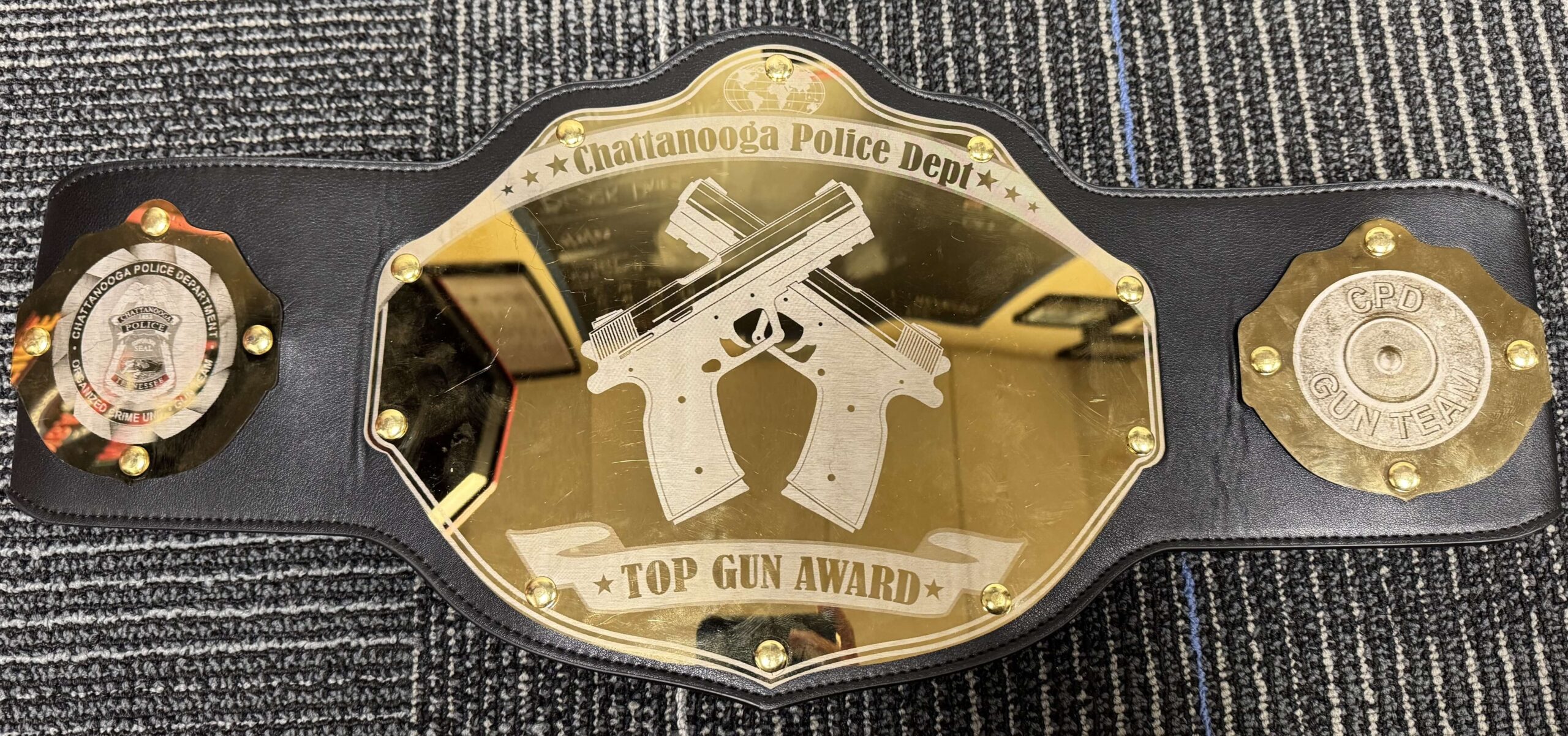 Championship-style belt awarded by the Chattanooga Police Department Gun Team. The central plate shows two crossed pistols with the words “Top Gun Award.”